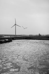 Wind turbines on landscape against sky