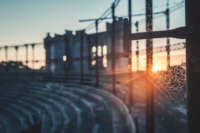 Spider web on pole against sky during sunset