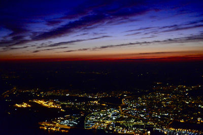 Illuminated cityscape against sky at night