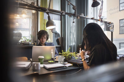 Bloggers working in creative office seen through glass