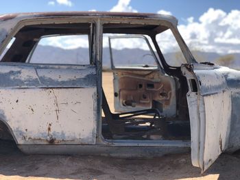 Abandoned car against sky