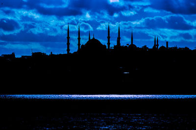 Built structures against cloudy sky at sunset