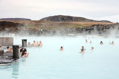 Group of people at swimming pool against sky