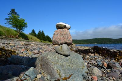 Stack of stones on beach against sky