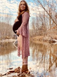 Portrait of woman standing by bare tree