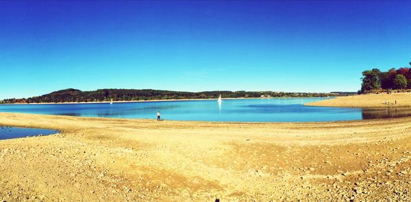 Scenic view of beach against clear blue sky