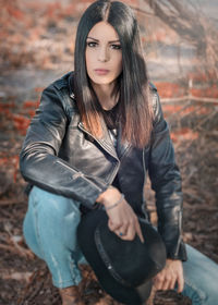 Portrait of young woman kneeling outdoors