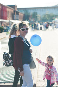 Rear view of woman and daughter in city