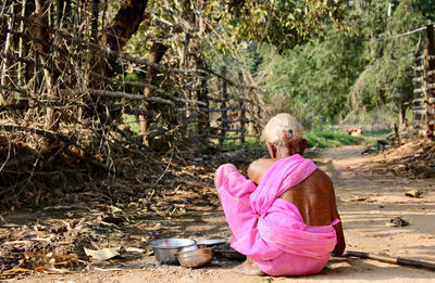 Rear view of young woman standing in forest