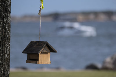 Close-up of birdhouse hanging against blurred background