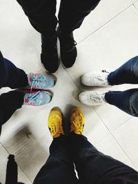 Low section of men standing on tiled floor