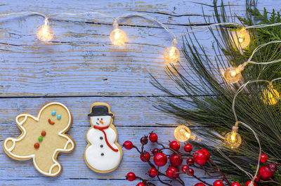 Directly above shot of gingerbread cookies on decorated wooden table