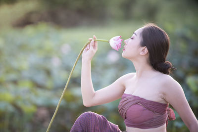 Side view of a young woman drinking water