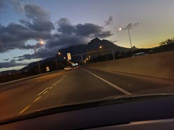 Cars on road against sky seen through car windshield