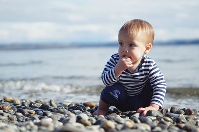 Portrait of happy boy with pebbles at beach