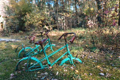 Bicycle parked by tree on field