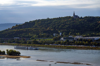 Scenic view of river by buildings against sky