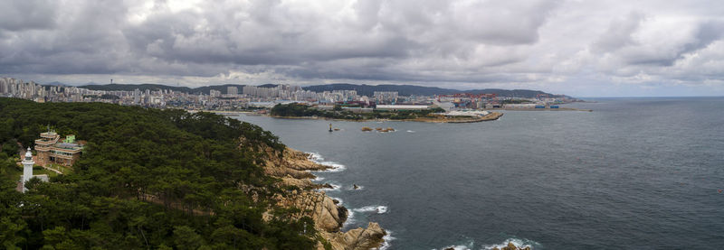 Panoramic view of sea and townscape against sky