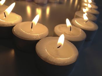 Close-up of burning candle on table in darkroom