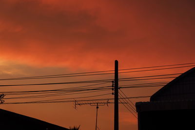 Low angle view silhouette electricity cable against sky during sunset