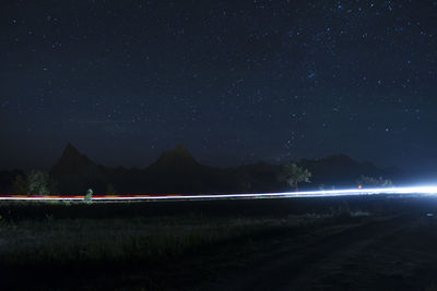 Scenic view of light trails against sky at night