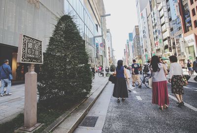 Rear view of woman walking on street in city