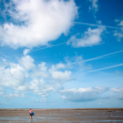 Scenic view of sea and a woman against sky