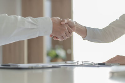Midsection of couple holding hands