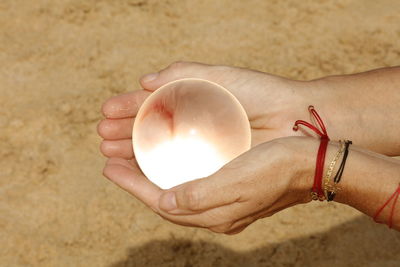 Close-up of woman hand holding sand at beach
