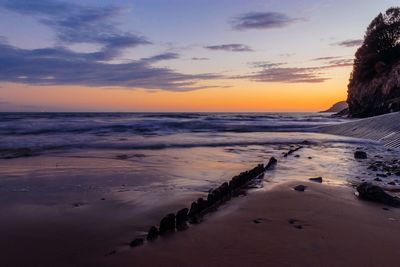 Scenic view of beach against sky during sunset