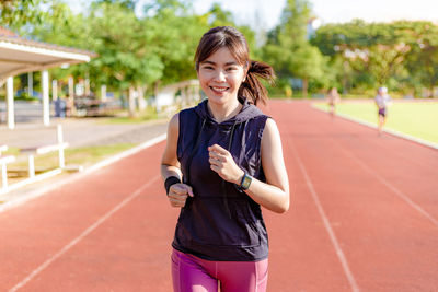 Portrait of smiling young woman standing outdoors