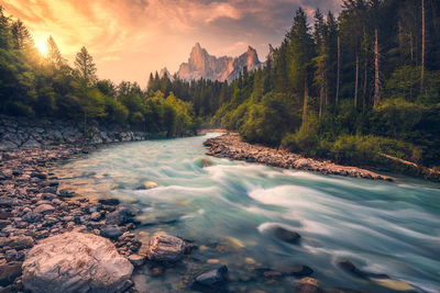 Scenic view of waterfall against sky during sunset