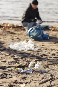 Young environmentalist collecting plastic waste by lake