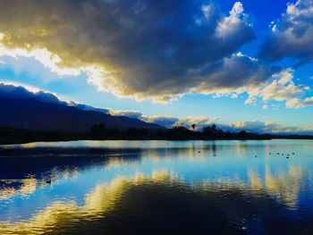 Scenic view of calm lake against cloudy sky