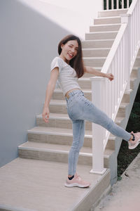 Portrait of happy young woman on staircase