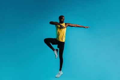 Man exercising against blue background