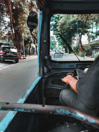 Man driving bajaj on street in city