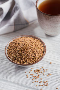 Bowl of fenugreek seeds and egyptian fenugreek yellow tea or methi dana drink