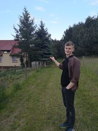 Portrait of young man standing on field