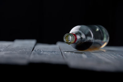 Close-up of bottle on table against black background