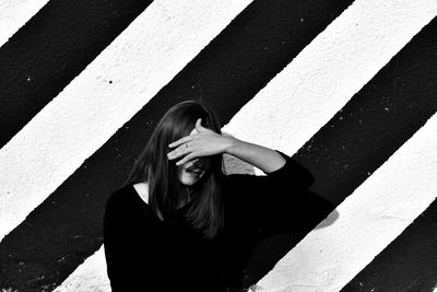 Young woman standing against wall