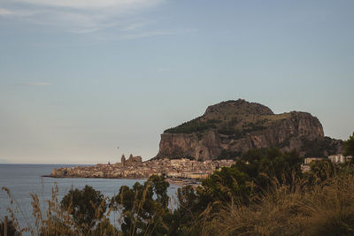 Scenic view of cliff by sea against sky
