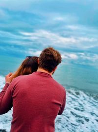 Rear view of man and woman looking at sea
