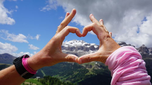 Close-up of man hand against sky