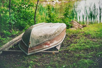 Upside down boat moored on lakeshore