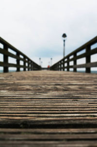 Surface level of footbridge on pier against sky