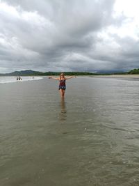 People standing on beach against sky