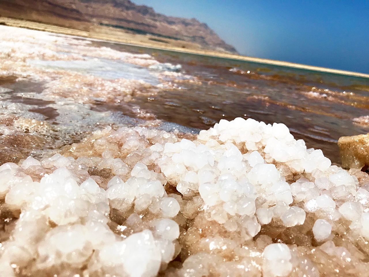 close-up, water, white color, no people, mineral, sea, nature, salt - mineral, beauty in nature, selective focus, focus on foreground, day, tranquility, beach, land, still life, cold temperature, outdoors, winter