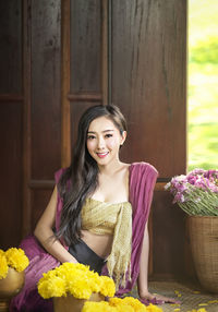 Portrait of a smiling young woman against blue wall