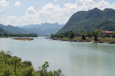 Scenic view of river and mountains against sky